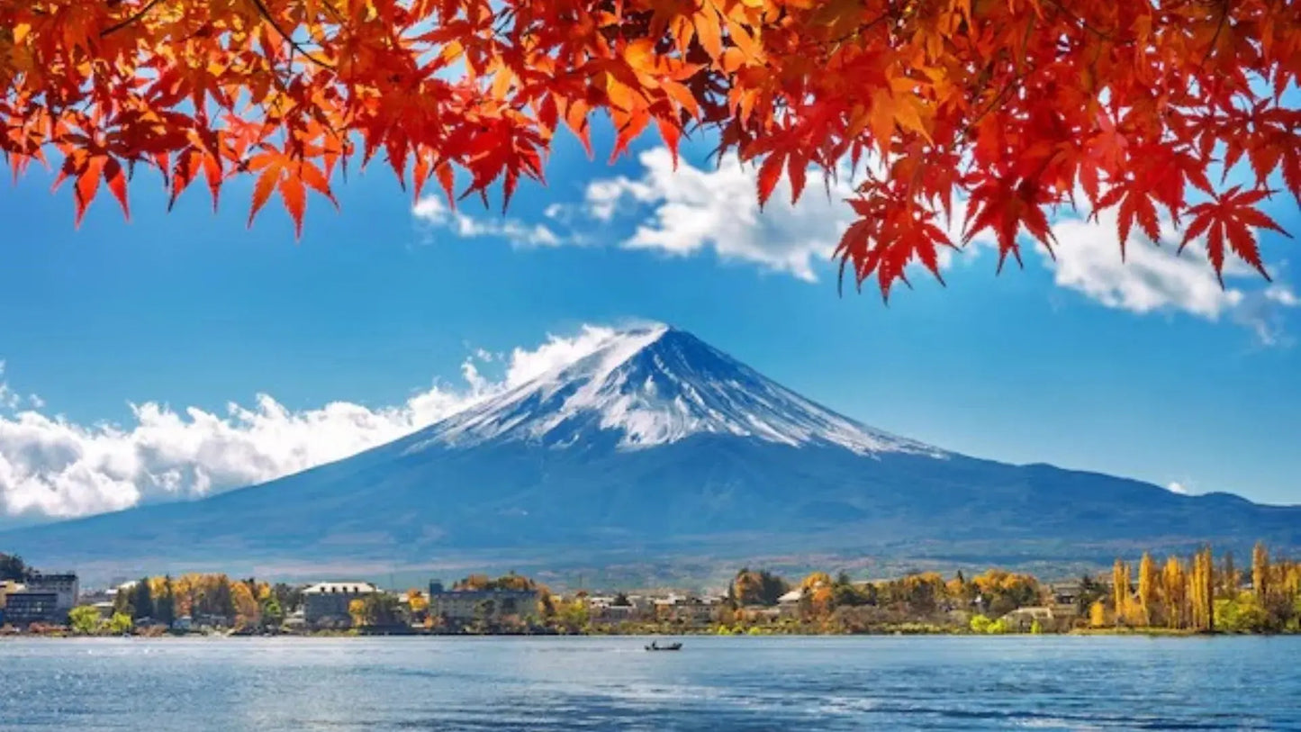 Snow-capped Mount Fuji reflecting on the calm waters of Lake Ashi during a scenic boat tour