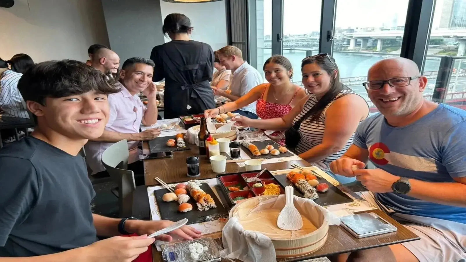 Participants practicing sushi rolling techniques during a hands-on class