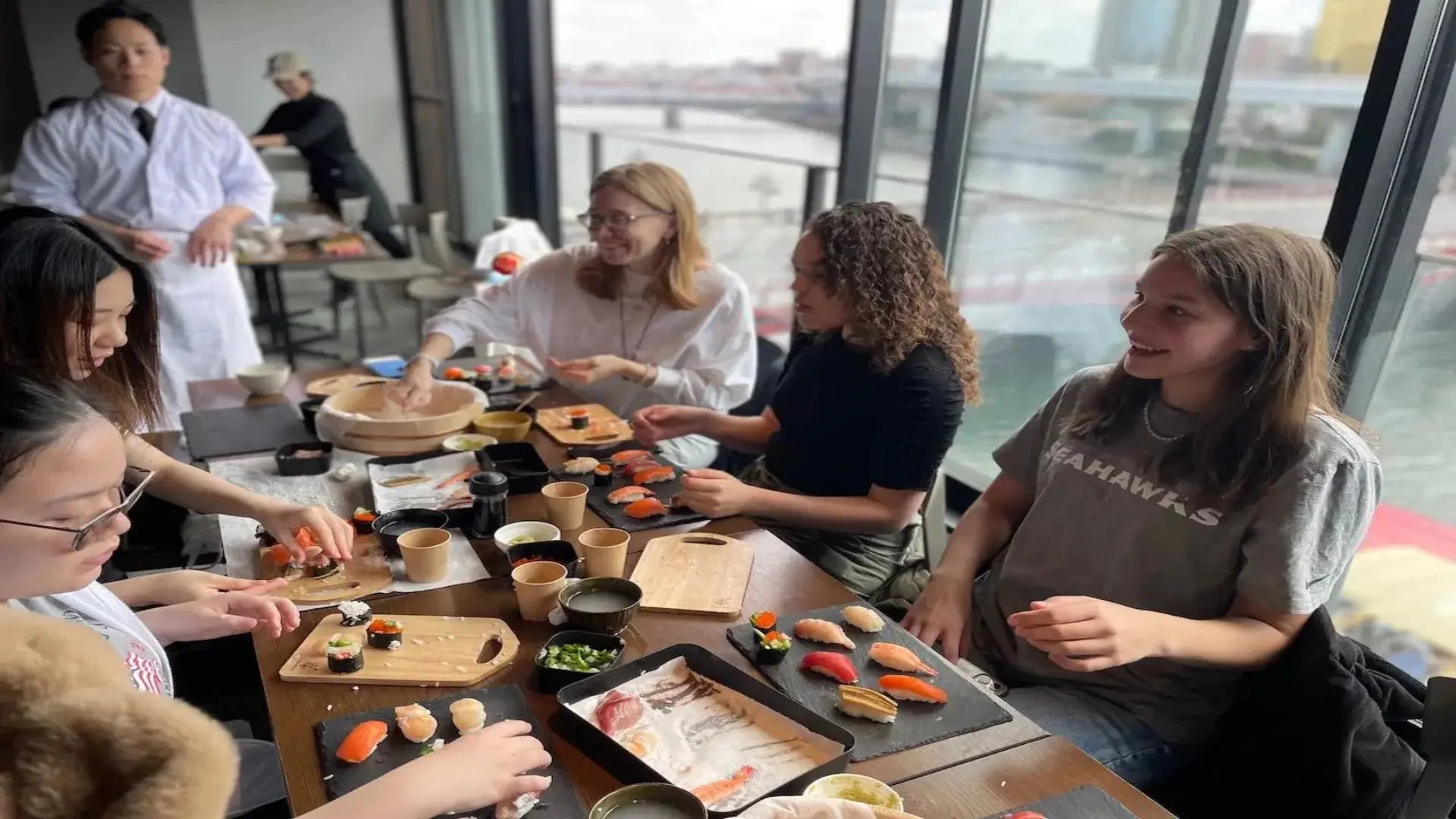 Customers enjoying a private sushi-making experience with a Japanese chef instructor